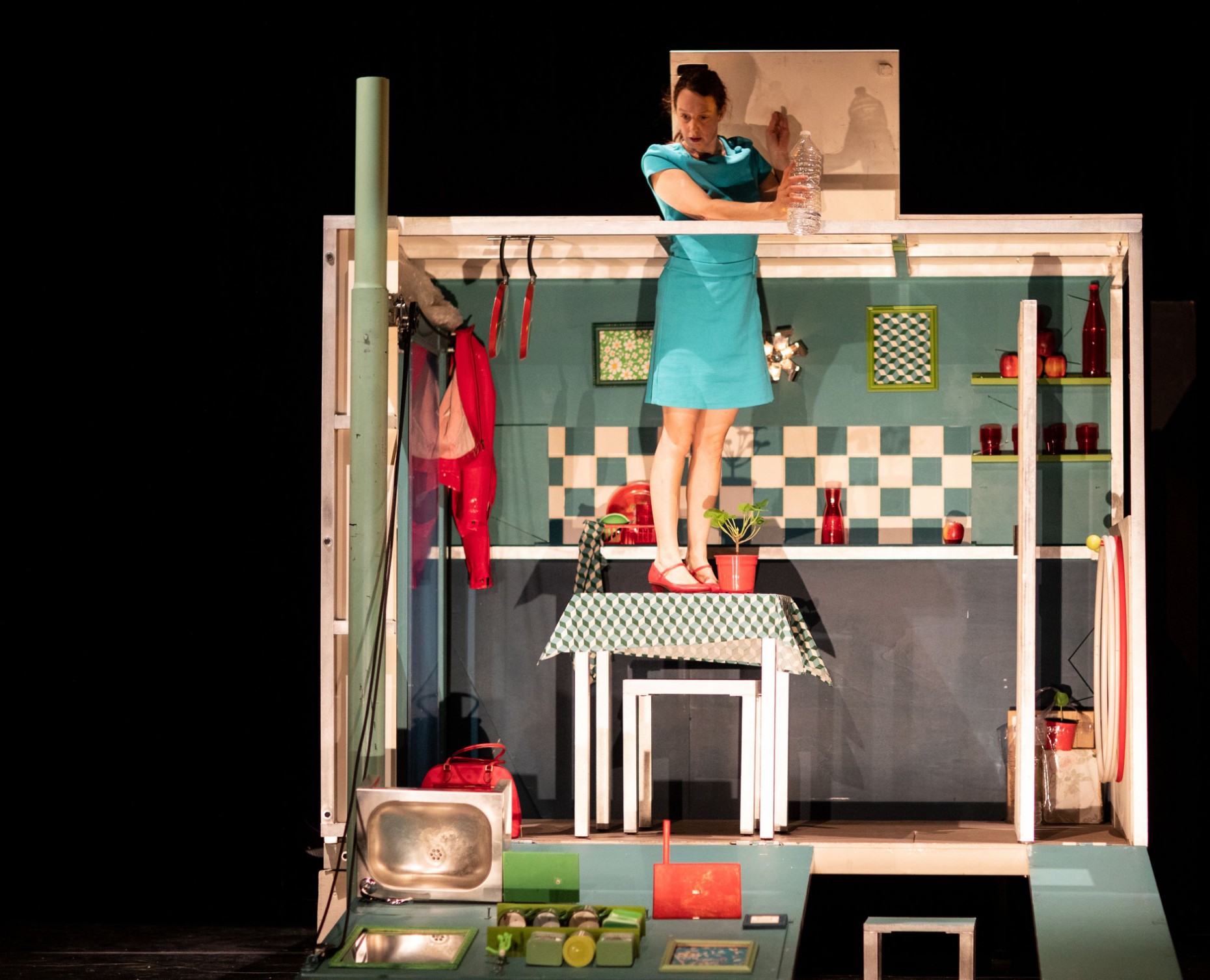 Juggler Karen Bourre standing on the table in the hut of the visual show for young audiences De la Nécessité de la Gravité